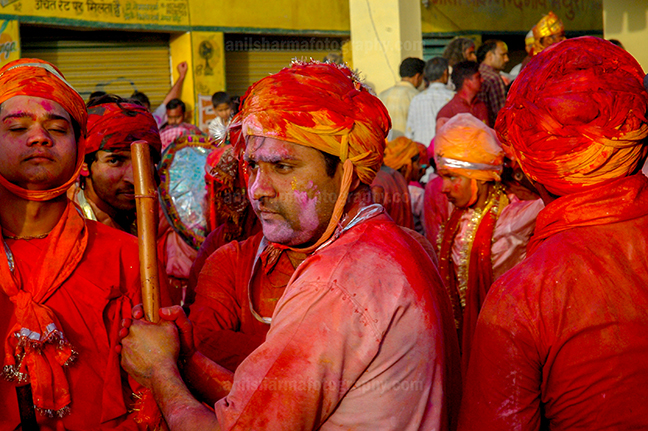 Festivals- Lathmaar Holi of Barsana (India) - A man daubed in color powder holding bamboo stick during lathmaar Holi at Barsana, Mathura, Uttar Pradesh, India. by Anil Sharma Photography