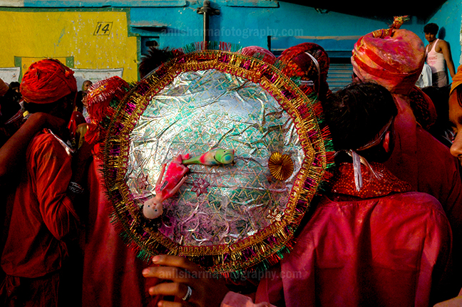 Festivals- Lathmaar Holi of Barsana (India) - A man daubed in color powder holding shield during Lathmaar Holi celebration at Barsana, Mathura Uttar Pradesh, India. by Anil Sharma Photography
