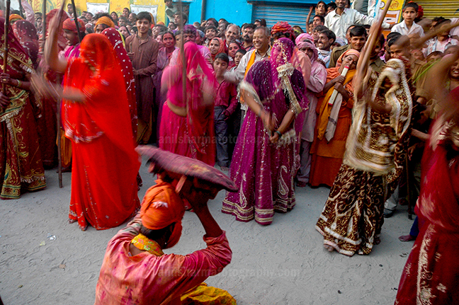 Festivals- Lathmaar Holi of Barsana (India) - A man from Nandgaon protecting himself from womens of Barsana hitting on his shield with their sticks during Lathmaar Holi at Barsana. by Anil Sharma Photography