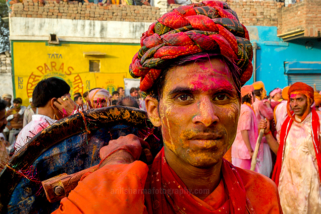 Festivals- Lathmaar Holi of Barsana (India) - A man daubed in color powder smiles as he celebrates lathmaar Holi at Barsana. by Anil Sharma Photography