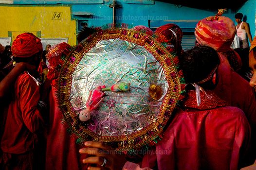 A man daubed in color powder holding shield during Lathmaar Holi celebration at Barsana, Mathura Uttar Pradesh, India.