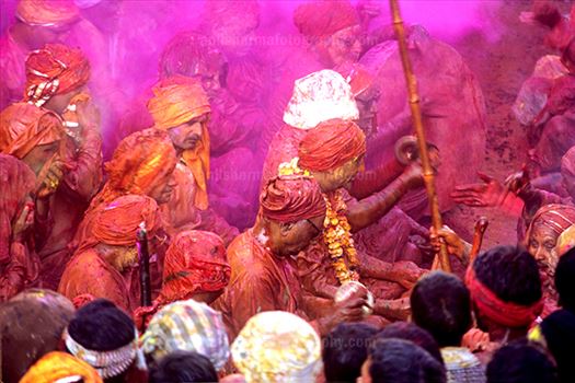 Festivals- Lathmaar Holi of Barsana (India) - People daubed in colored water, head covered singing a hymn during Lathmaar Holi celebrations at Barsana, Mathura, India.