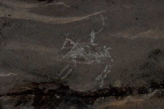 Prehistoric Rock Painting of a men riding horse in white color at Bhimbetka archaeological site