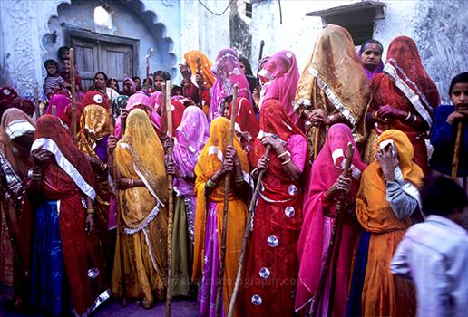 women's wearing colorful saree's holding bamboo sticks during Lathmaar Holi at Barsana, Mathura, Uttar Pradesh, India.