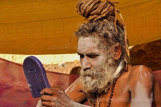 A Naga sadhu holding mirror in his hand at Varanasi ghat.