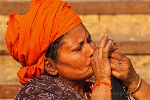 A women Naga Sadhu enjoying clay pipe smoking at Varanasi ghat.