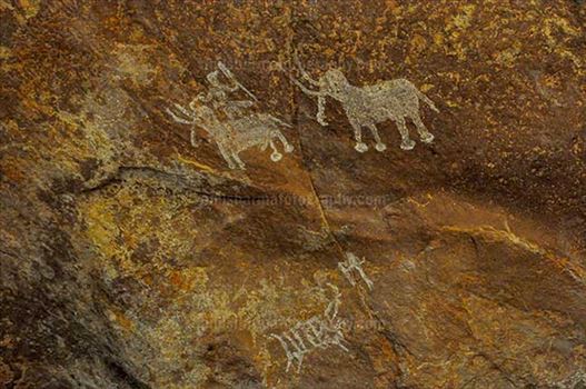 Prehistoric rock painting of men with two Elephants at Bhimbetka archaeological site.